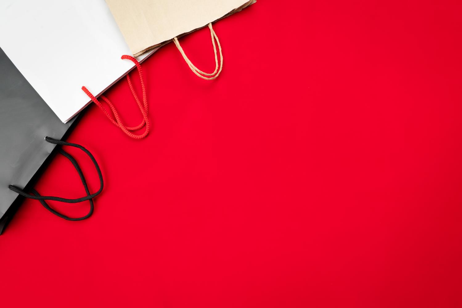 Paper shopping bags on red background